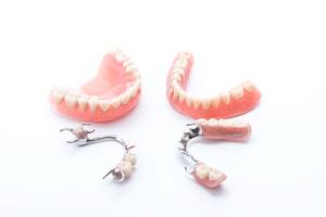 Full and partial dentures arranged against neutral backdrop