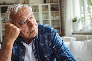 Sad senior man looking out the window