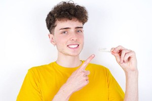 Teenage boy pointing at his Invisalign aligner