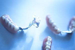 Partial dentures arranged on tabletop, casting shadows