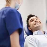 Man smiling at dentist  after replacing a knocked out tooth