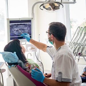 Dentist and patient looking at x-ray of tooth in  need of extraction