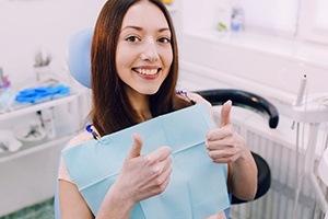 Woman giving thumbs up after tooth extraction