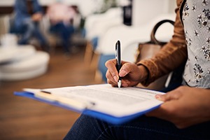 Patient filling out forms in dental clinic waiting room