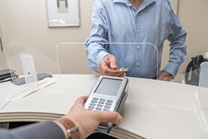 Patient handing over card to pay for dental treatment