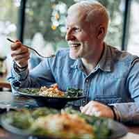 Happy senior man eating a delicious meal