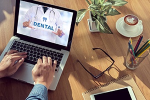 Patient using laptop computer to learn about dental benefits