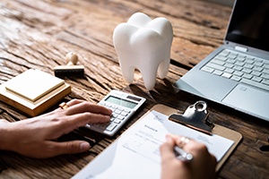 Using calculator to budget for cost of dental implants