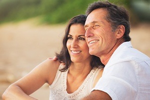 Man and woman smiling after dental implant tooth replacement