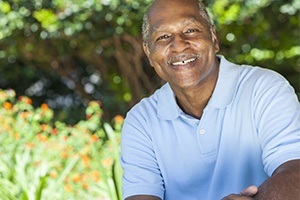 Man sharing flawless smile after dental implant tooth replacement