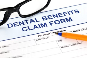 Dental benefits claim form with glasses and pen