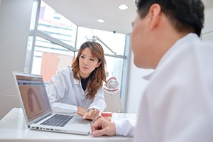 Dental team using computer to plan patient’s smile makeover