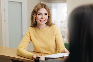 Patient interacting with dental team member at front desk