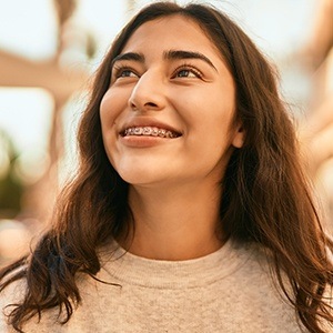 Young woman with traditional orthodontics smiling