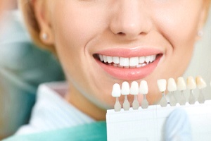 Closeup of patient’s teeth next to dental shade guide after teeth whitening