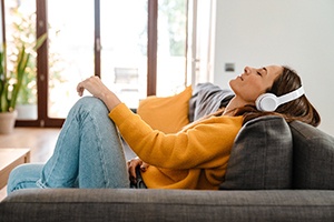 Young woman listening to music while resting on sofa