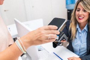Dental team member accepting payment from patient