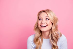 Woman smiling confidently after fixing her small teeth in Westborough