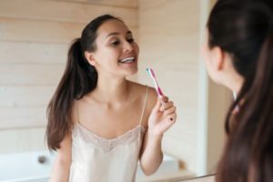Woman in front of mirror, holding toothbrush