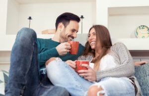 Couple on sofa, drinking coffee