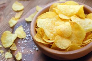 Bowl of potato chips sitting on table