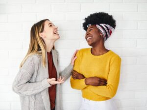 Two female friends laughing during conversation 