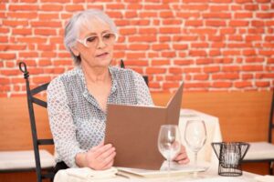 Senior woman looking at menu in restaurant 