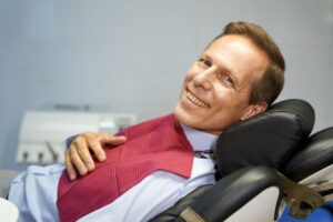 Smiling middle-aged man in dental treatment chair 