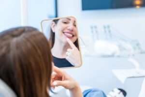 Cosmetic dentistry patient smiling at herself in mirror